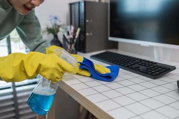a company's cleaning lady is diligently cleaning the executive's office, the cleaning lady wears rubber gloves to prevent irritation form chemicals while cleaning